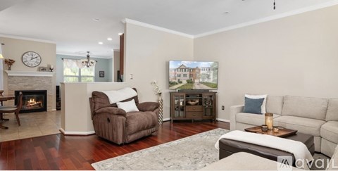 A living room with a fireplace and a painting on the wall.