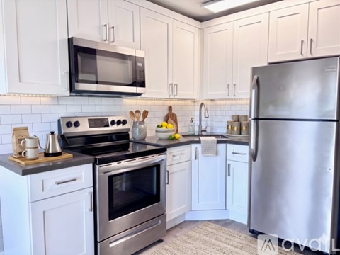 A modern kitchen with white cabinets and stainless steel appliances.