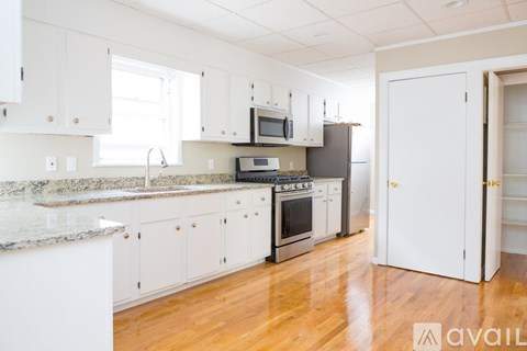 A kitchen with white cabinets and a granite countertop.