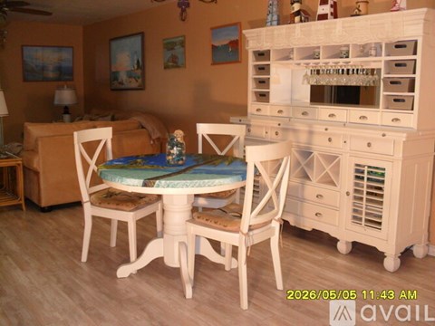 A dollhouse living room with a dining table and chairs.