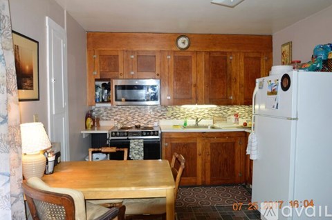 A kitchen with wooden cabinets and a white refrigerator.