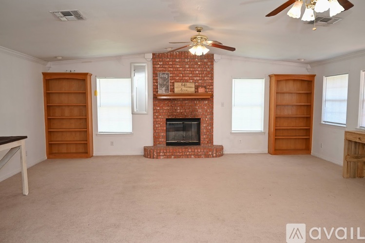A living room with a fireplace and a ceiling fan.