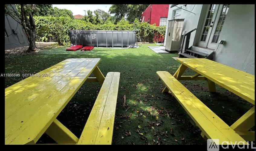 A yellow picnic table and benches are set up in a grassy area.