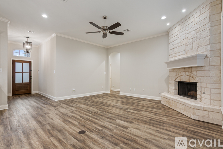 A spacious living room with a fireplace and wood flooring.