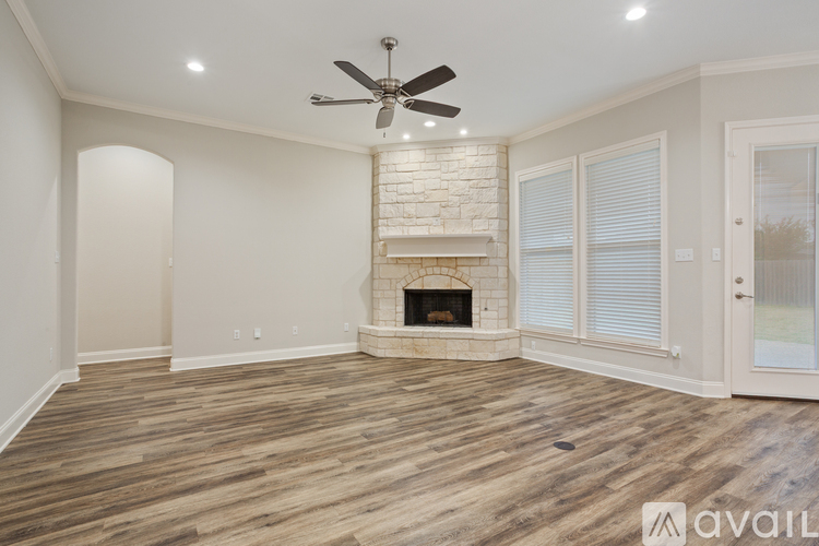 A spacious room with a fireplace and wood flooring.