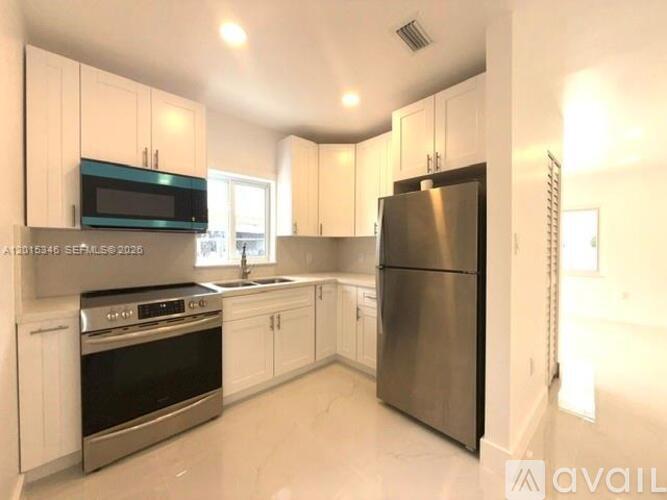 A kitchen with white cabinets and stainless steel appliances.