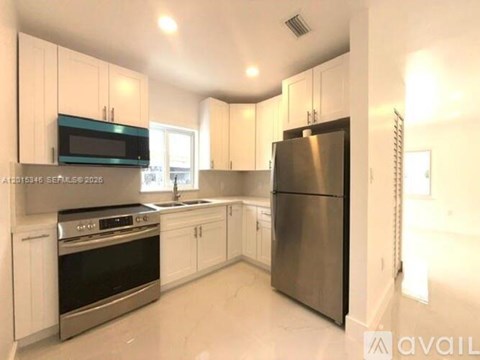 A kitchen with white cabinets and stainless steel appliances.
