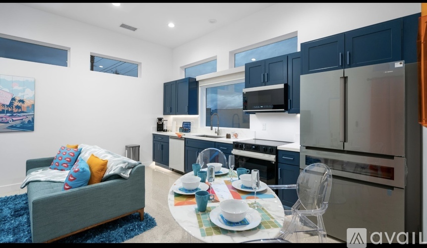 A modern kitchen with a dining table set for two.