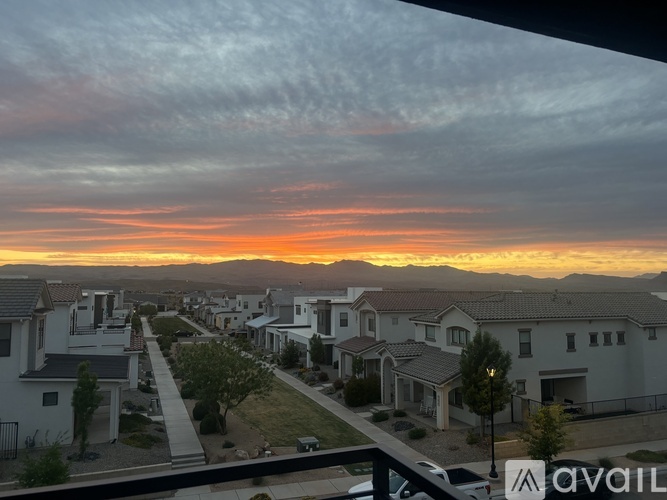 A neighborhood with houses and a sunset in the background.