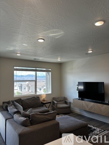 A living room with a grey couch and a television.