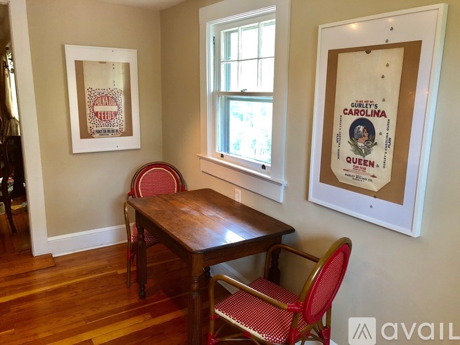 A dining room with a wooden table and chairs.