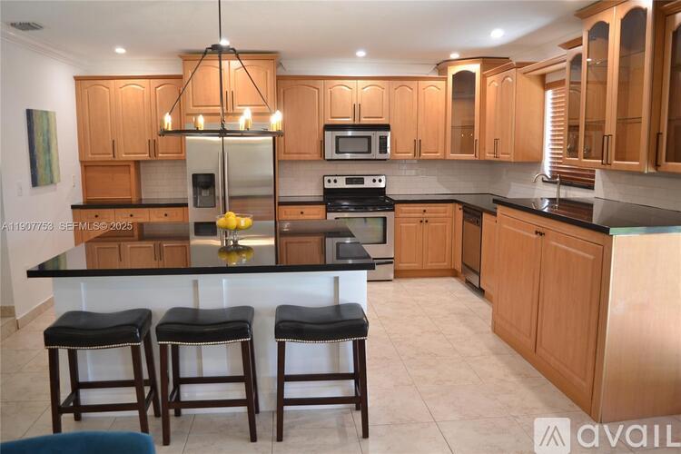 A kitchen with wooden cabinets and black countertops.