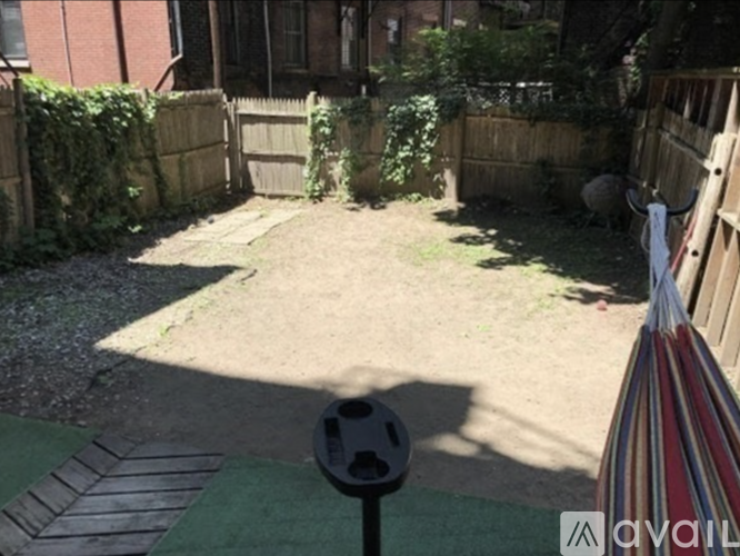 A backyard with a soccer ball and a striped umbrella.