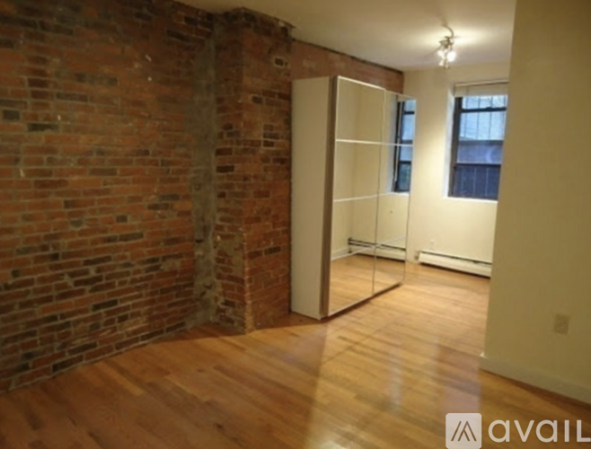 A room with a brick wall and wooden floors.