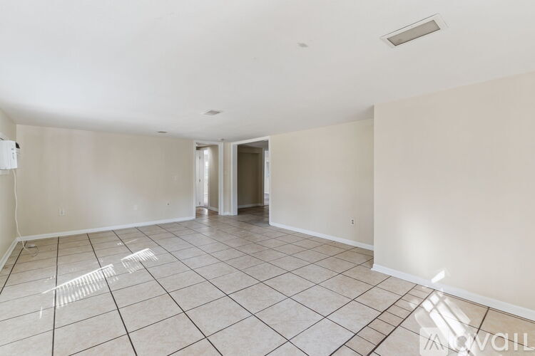 A spacious room with white walls and a tiled floor.