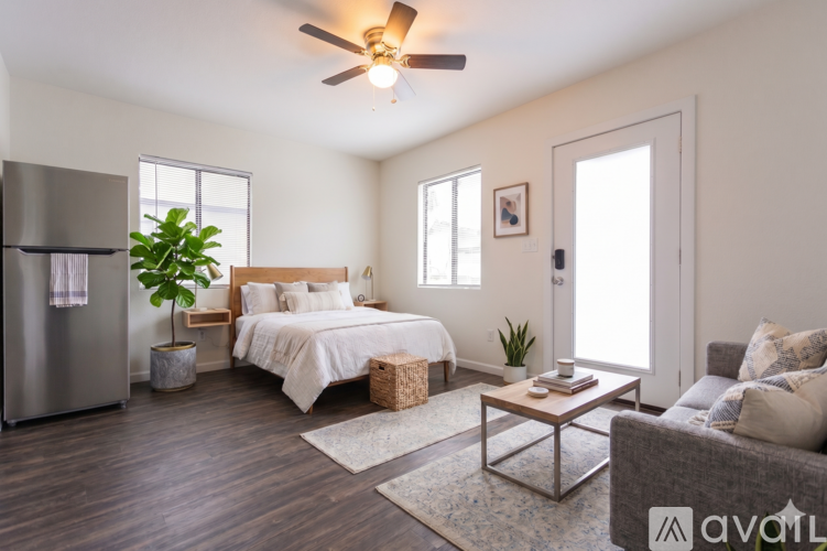 A bedroom with a bed, a couch, and a ceiling fan.