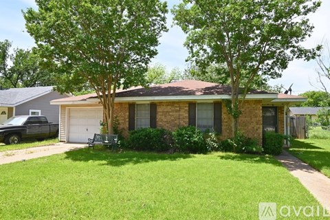 A house with a lawn and trees in front of it.