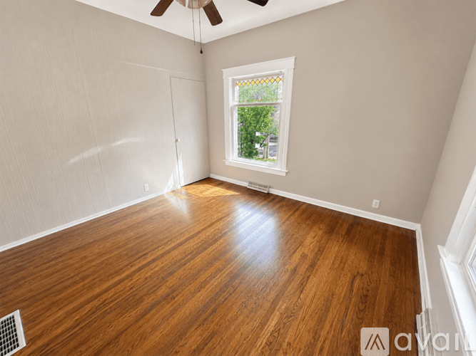 A room with wooden flooring and a window.