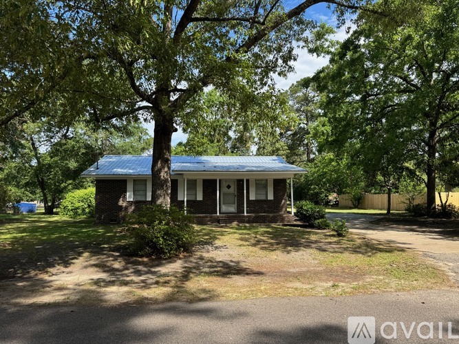 A house with a blue roof is surrounded by trees.