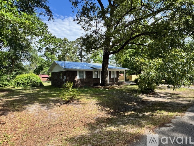 A house with a blue roof is surrounded by trees.
