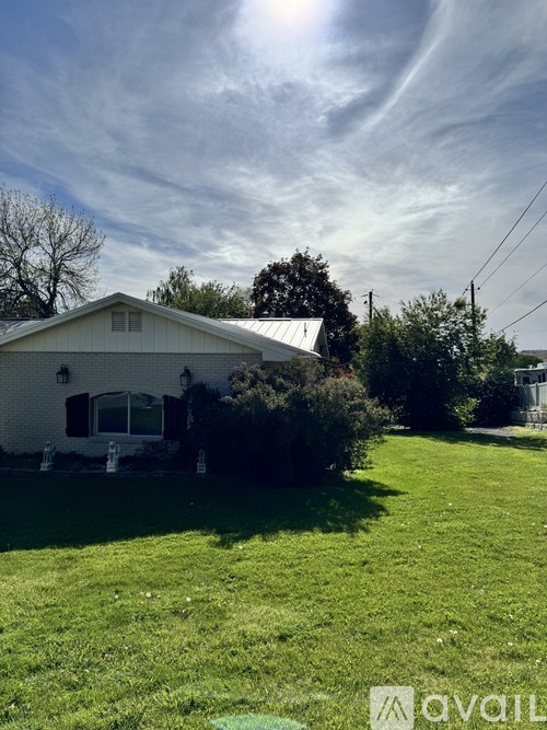 A house with a white exterior and a green lawn in front.