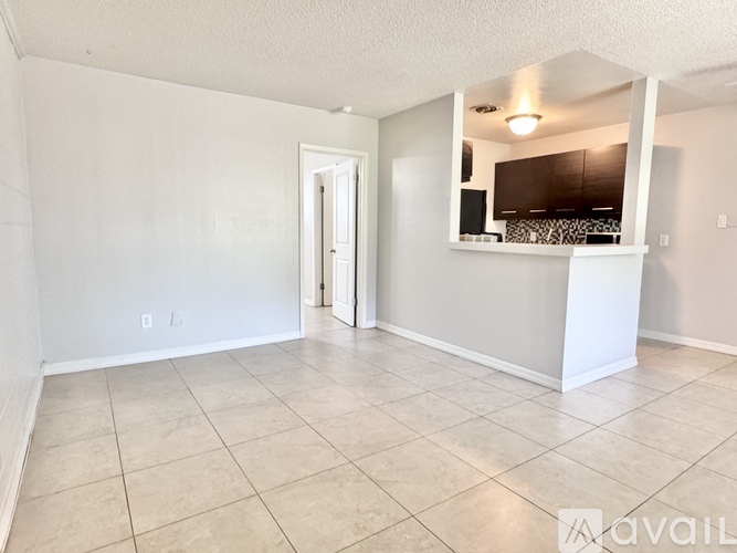 A spacious room with a tiled floor and a mirrored cabinet.