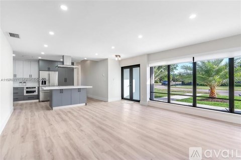 A spacious kitchen with a large island and a view of the outdoors.