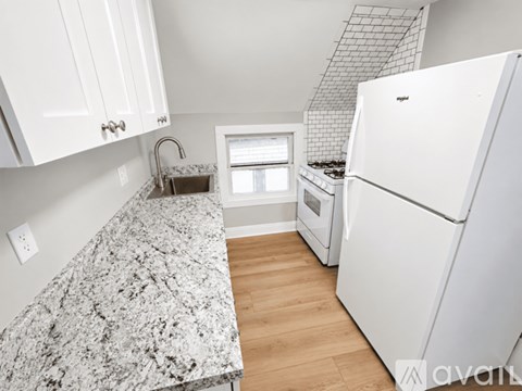 A kitchen with a granite countertop and white appliances.