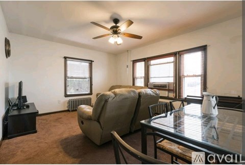 A living room with a brown carpet and a glass table.