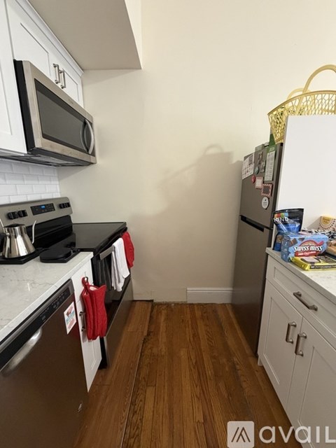 A kitchen with white cabinets and a black stove top.