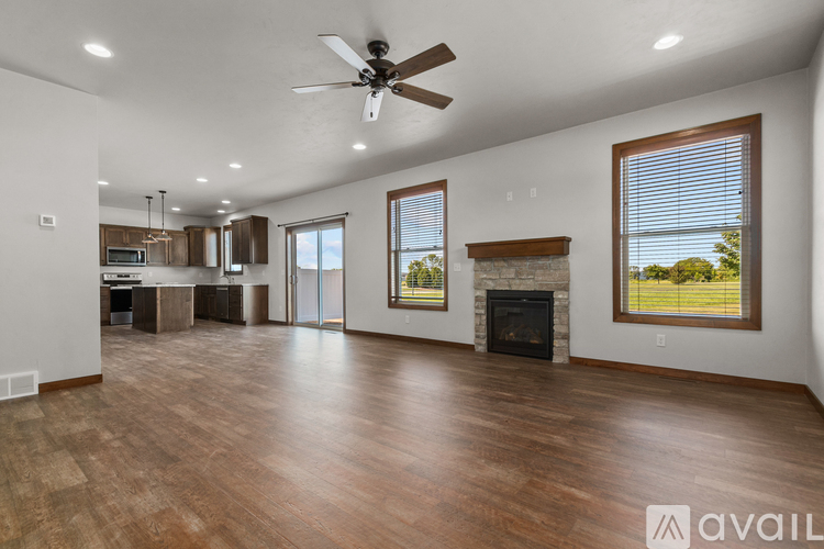 A spacious living room with wood flooring and a fireplace.