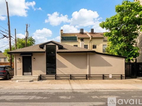 A house with a black door and a sign that says "available" in front of it.