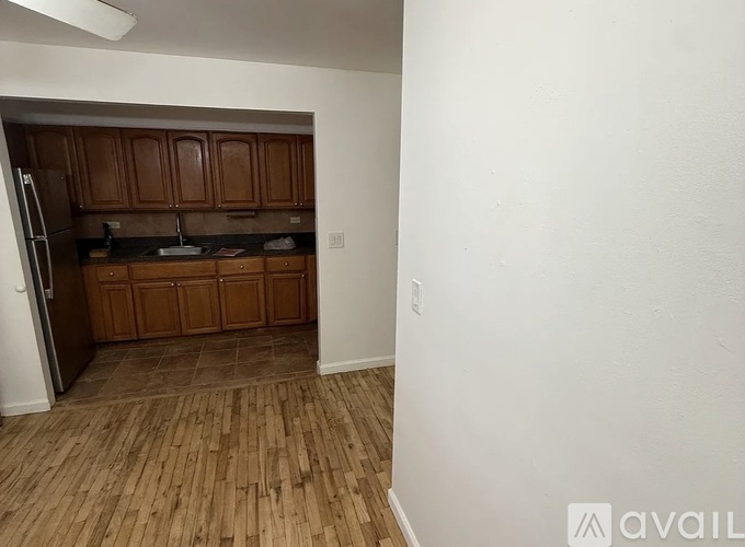A kitchen with wooden cabinets and a refrigerator.
