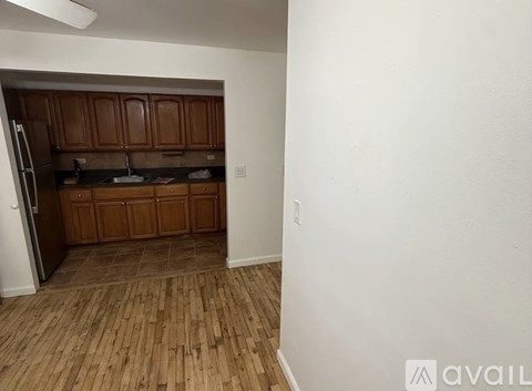 A kitchen with wooden cabinets and a refrigerator.