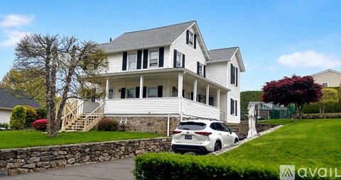 A white house with a car parked in front.