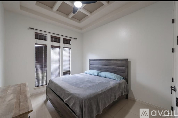 A bedroom with a bed, window, and wooden headboard.