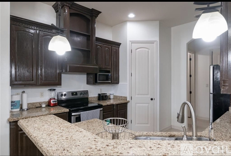 A kitchen with brown cabinets and a granite countertop.