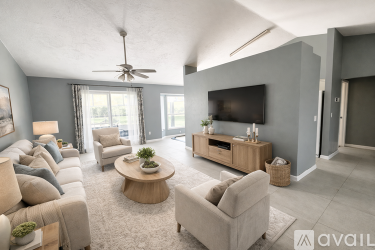 A spacious living room with a large couch, a coffee table, and a flat-screen TV.