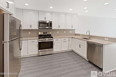 A kitchen with white cabinets and stainless steel appliances.