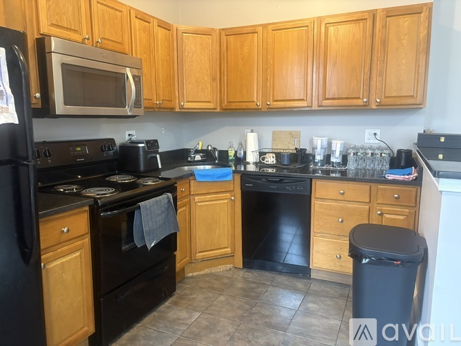 A kitchen with wooden cabinets and black appliances.