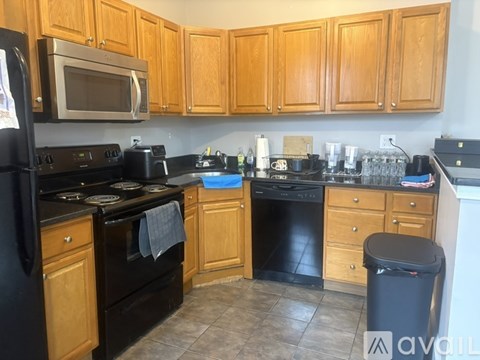 A kitchen with wooden cabinets and black appliances.
