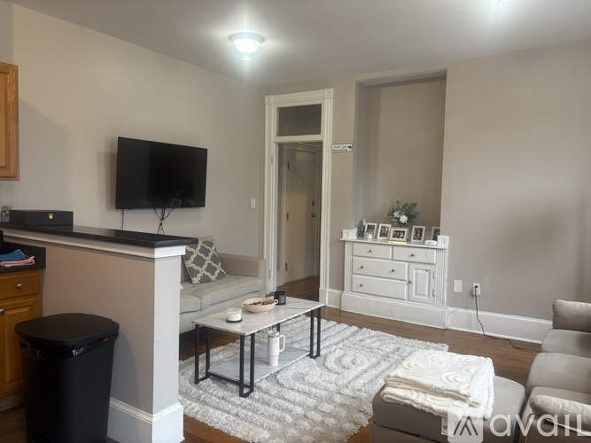 A living room with a flat screen TV mounted on the wall.