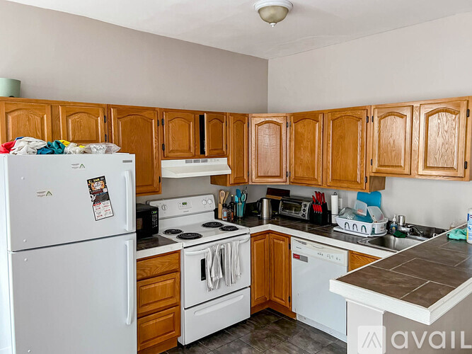 A kitchen with wooden cabinets and white appliances.