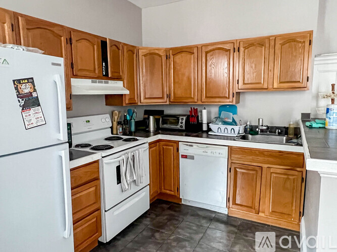 A kitchen with wooden cabinets and white appliances.
