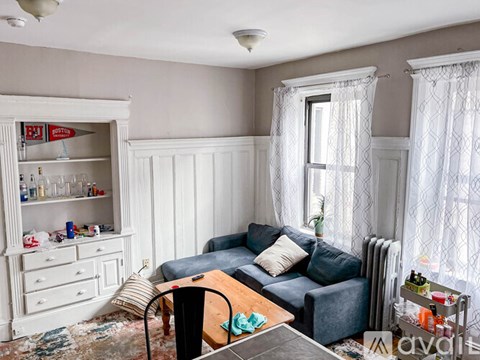 A living room with a grey couch and a wooden coffee table.