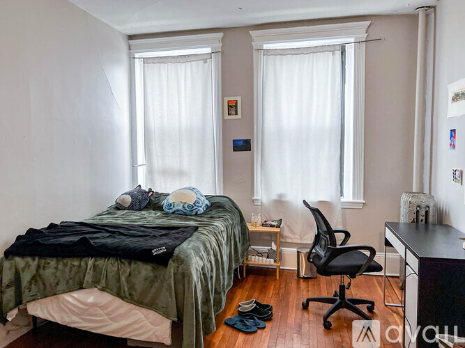 A bedroom with a bed, desk, and chair.