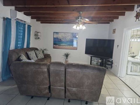 A living room with two brown couches and a television.