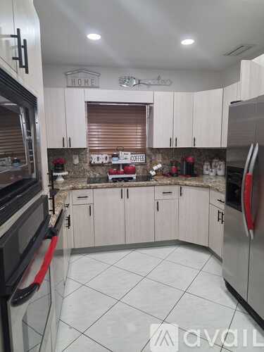 A kitchen with white cabinets and a black stove top oven.