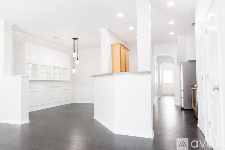 A spacious kitchen with white cabinets and a wooden island.