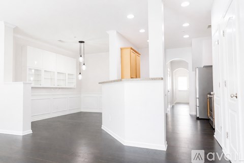 A spacious kitchen with white cabinets and a wooden island.